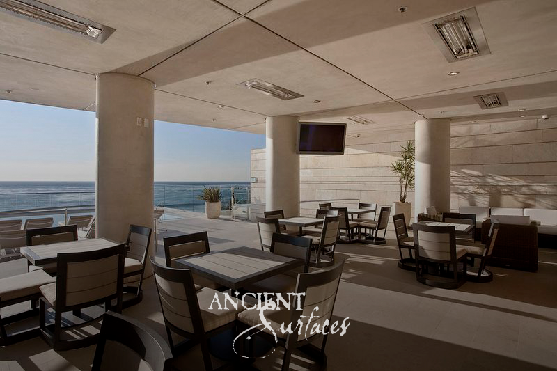 Covered oceanfront loggia with reclaimed limestone wall cladding and stone-paved floors