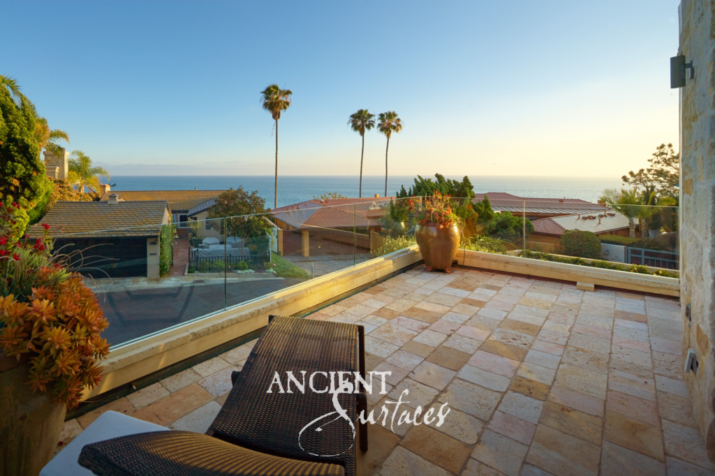 Antique reclaimed limestone paved terrace overlooking the ocean at sunset