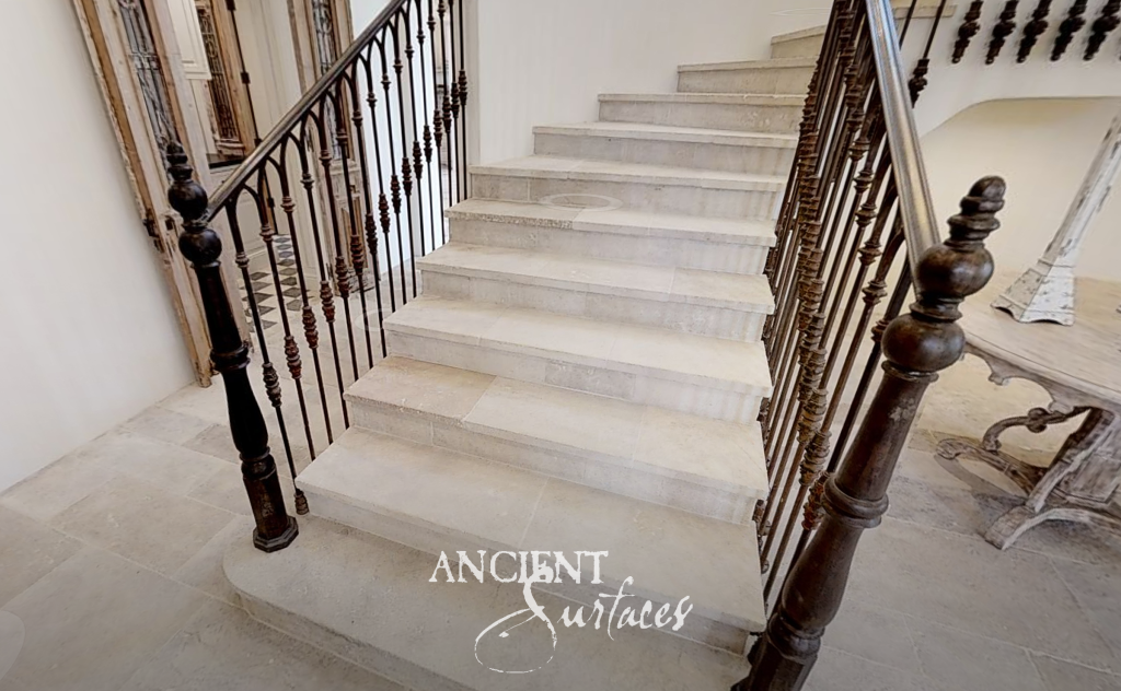 Reclaimed limestone staircase and flagstone landing with an antique wrought-iron balustrade