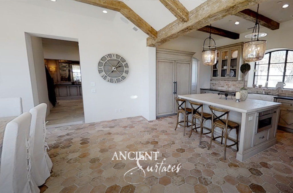 Open kitchen and dining room with antique terracotta hexagon flooring beneath reclaimed timber beams