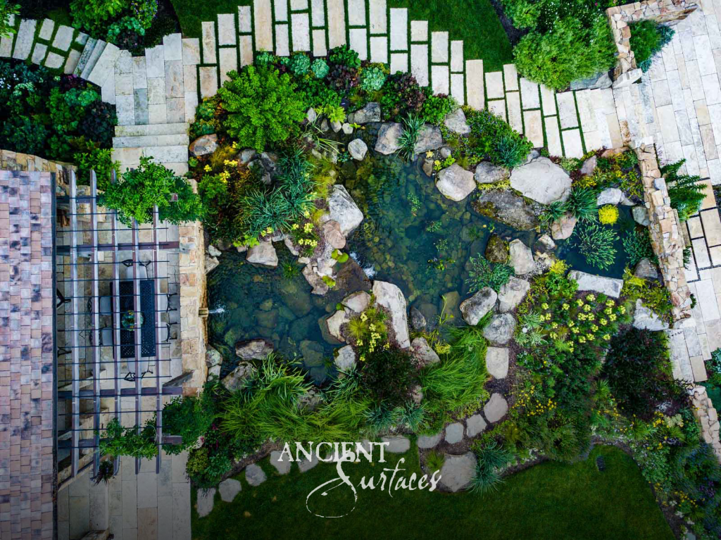 Overhead view of a natural stone pond framed by reclaimed limestone paving and stepping stones