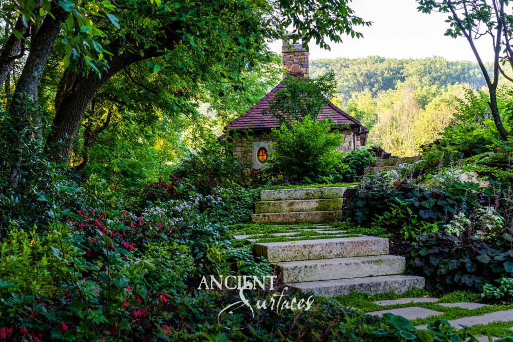 Antique limestone garden steps and stepping stones climbing through planting to a stone cottage